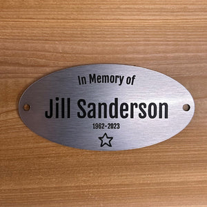Memorial plaque for  on a wooden background